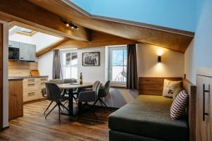 a room with a bed and a table with chairs at B&B Gästehaus Alpenblick in Lermoos