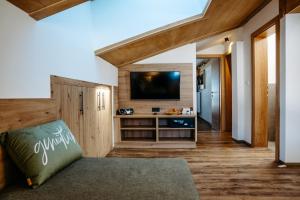 a living room with a television and a couch at B&B Gästehaus Alpenblick in Lermoos