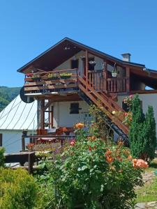 a house with a balcony and some flowers at Privatni smještaj Kurtalija in Jajce