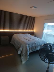 a bedroom with a bed and a chair and a window at Pousada Mineiro in Curitiba