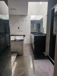 a large bathroom with a sink and a mirror at Pousada Mineiro in Curitiba