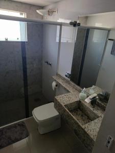 a bathroom with a toilet and a sink and a mirror at Pousada Mineiro in Curitiba +4 photos