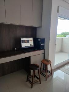 a kitchen with a laptop computer on a counter with two stools at Pousada Mineiro in Curitiba