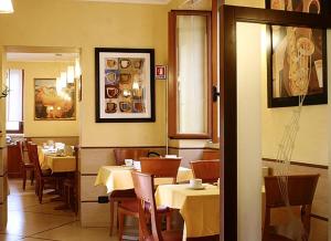 a dining room with tables and chairs in a restaurant at Hotel Lirico in Rome