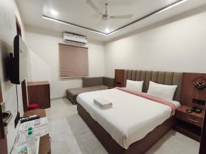 a bedroom with a bed and a television in it at Hotel Gurukripa in Ujjain