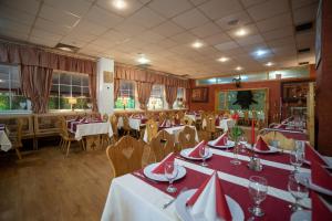 a restaurant with tables and chairs with red and white tablecloths at Hotel Dominika in Bratislava