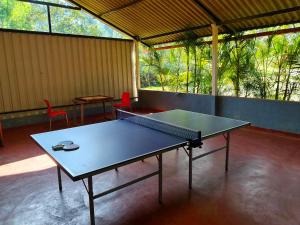 a ping pong table in a room with two chairs at THE DOCkSIDE INN in Madikeri