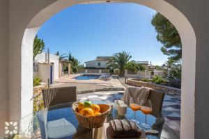 a table with a bowl of fruit and glasses of wine at Villa Ananas by Abahana Villas in Moraira +15 photos