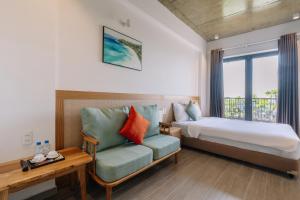 a bedroom with a bed and a couch and a window at The Shine Hotel & Apartment in Danang +62 photos