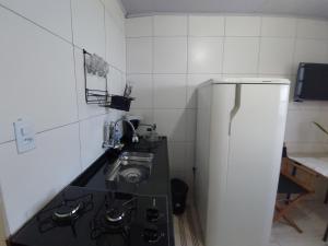 a small kitchen with a sink and a refrigerator at Casa da Angela Quarto Triplo in Rio de Janeiro