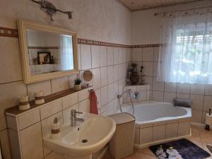 a bathroom with a tub and a sink and a mirror at fewo-aller-auszeit in Hademstorf +39 photos