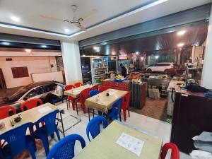 a restaurant with tables and chairs and a car inside at Hotel Gurukripa in Ujjain