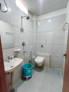 a white bathroom with a toilet and a sink at Hotel Gurukripa in Ujjain +38 photos