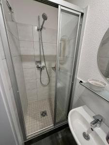 a shower with a glass door next to a sink at Tiny House Nike in Tettnang +12 photos