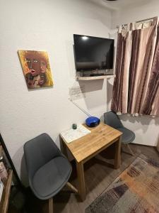 a room with two chairs and a table and a tv at Tiny House Nike in Tettnang