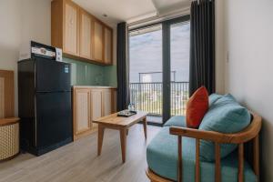 a kitchen with a couch and a table and a refrigerator at The Shine Hotel & Apartment in Danang