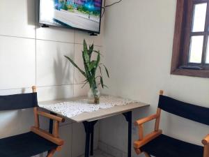 a table with two chairs and a plant on it at Casa da Angela Quarto Triplo in Rio de Janeiro