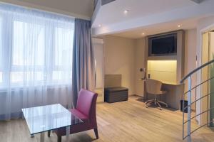 a room with a table and a chair and a desk at Garner Hotel Stuhr - Bremen A1 by IHG in Bremen