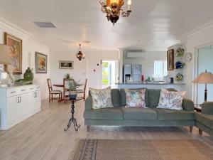 a living room with a green couch and a kitchen at The Estuary Country Estate, Villa "Once Upon A Tide" in Port Edward +50 photos