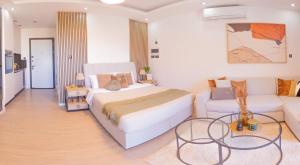 a bedroom with a white bed and a couch at Palmera - Spacious Studio with Pool View in Vasilia