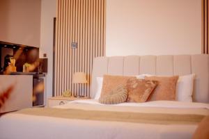 a large white bed with two pillows on it at Palmera - Spacious Studio with Pool View in Vasilia +24 photos