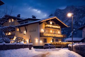 a building with a balcony in the snow at night at B&B Gästehaus Alpenblick in Lermoos