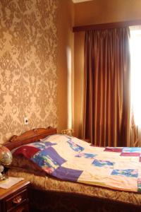 1 cama en un dormitorio con ventana en Guesthouse Valeria, en Borjomi