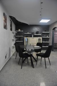 a dining room with a table and black chairs at Glow Sahara in Focşani