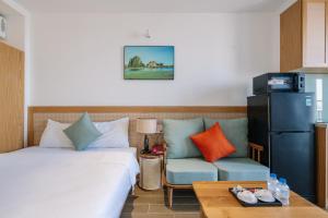 a room with a bed and a couch and a chair at The Shine Hotel & Apartment in Danang