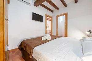 a bedroom with a large white bed with two towels on it at Portal del Carro 7 Junto a la Catedral in Tarragona