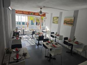 a dining room with tables and chairs and a large window at Residencial Melba in Funchal