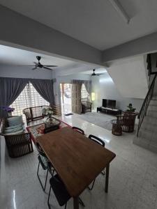 a living room with a wooden table and chairs at TWS Homestay in Batu Caves