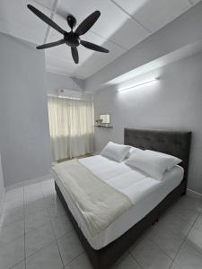 a bedroom with a bed with a ceiling fan at TWS Homestay in Batu Caves
