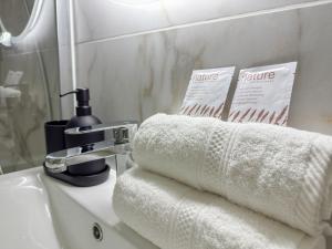 a bathroom sink with towels and a faucet at Studio M in Mondeville
