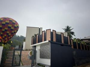 a hot air balloon next to a building and a hot dog at Bumblebee Pool Villa Munnar in Anachal