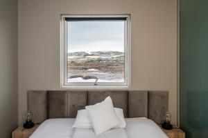 a bedroom with a bed with a window above it at The Highland Center Hrauneyjar in Sprengisandur +82 photos
