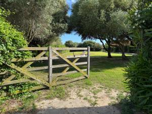 a wooden gate in a field with trees at Trafalgar Polo Club in El Palmar