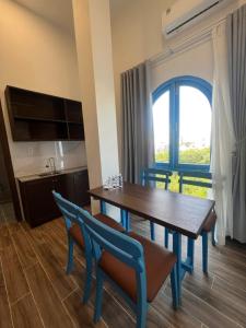 a dining room with a table and chairs and a window at Nhã Hotel A in Thôn Mỹ Phước