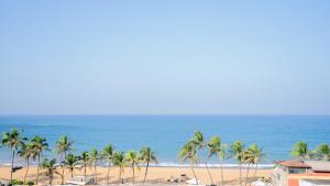 a view of a beach with palm trees and the ocean at Crystal Sand Mount Lavinia in Mount Lavinia