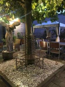 a table and chairs under a tree with a statue at Tiny House Nike in Tettnang