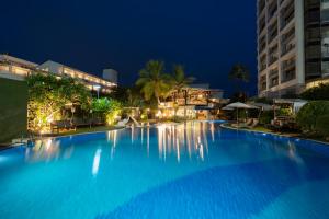 a large swimming pool in a resort at night at Natural Park Resort Pattaya in Jomtien Beach