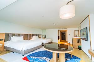 a hotel room with two beds and a table at Montien Hotel Surawong Bangkok in Bangkok