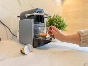 a person is making a drink in a coffee machine at Studio M in Mondeville
