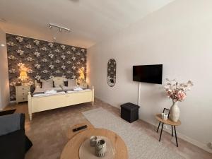 a living room with a bed and a tv at Målkullorna Hostel in Mora