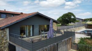 a house with a deck and a swimming pool at Hitton Séjours Nature in Biran