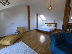 a bedroom with a bed and a couch and a chair at Wildglowlodge in Petroşani