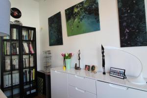 a living room with a white dresser and bookshelves at Appartement contemporain Les Tulipes, 2 personnes à 300 m du lac de Gérardmer in Gérardmer