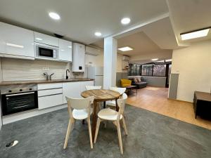 a kitchen and dining room with a table and chairs at Incredible house with garden in Madrid