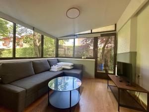 a living room with a couch and a glass table at Incredible house with garden in Madrid