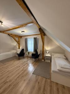 a bedroom with a bed and chairs in a attic at Domek Ostoja Energylandia Zator Graboszyce in Graboszyce